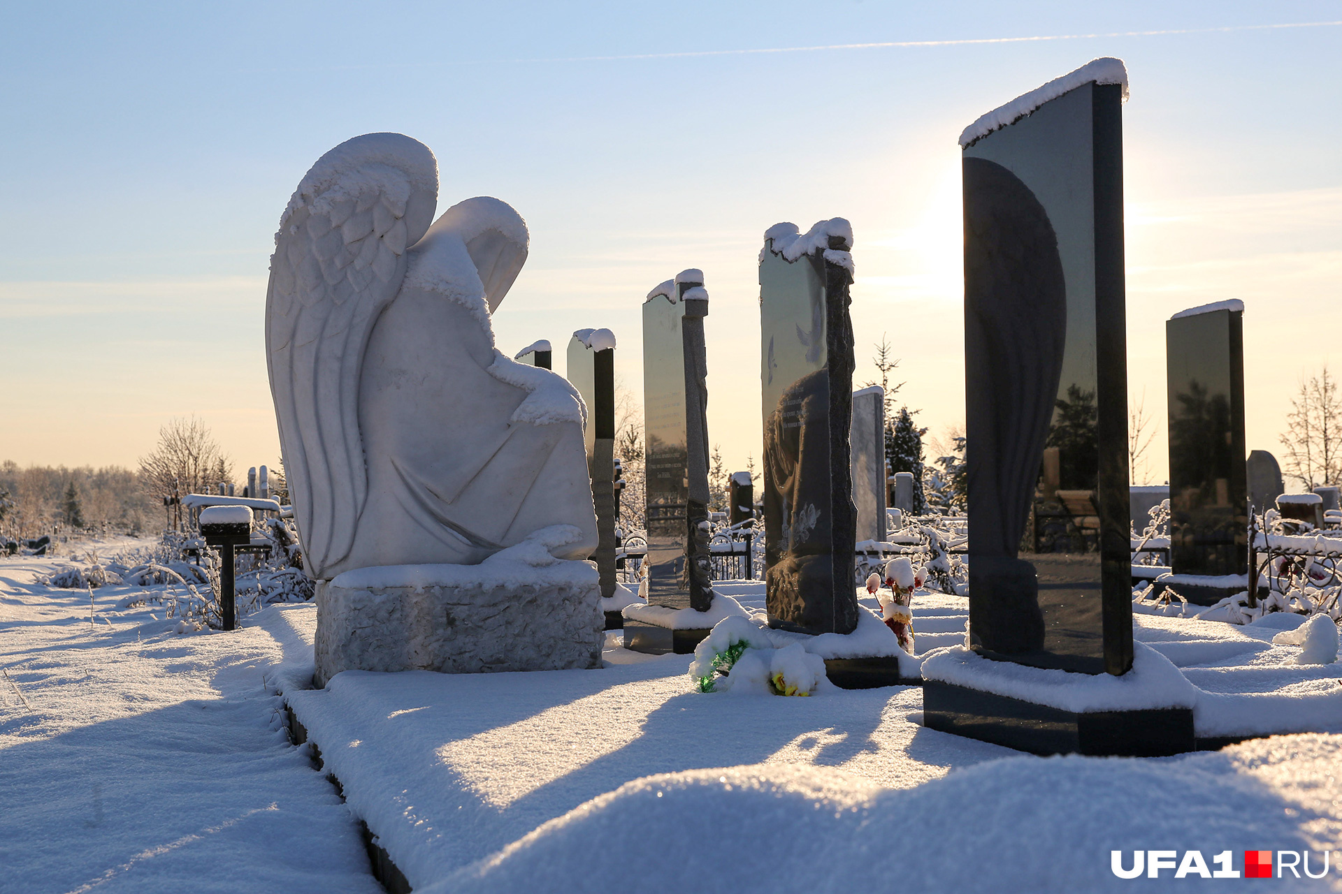 Скульптура ангела будто охраняет могилы