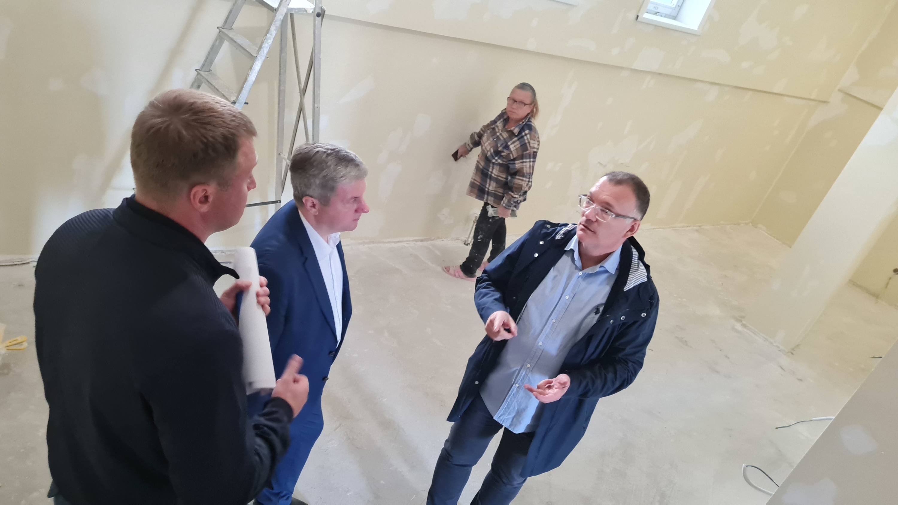 Внутри здания строители делают отделку помещений Внутри здания строители делают отделку помещений