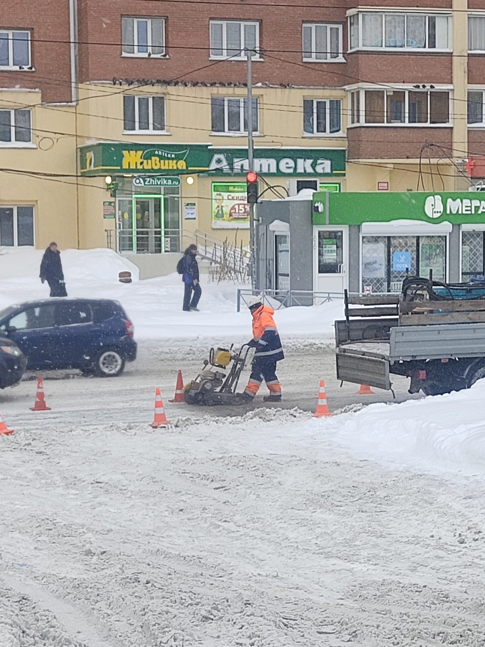 Дорожные рабочие начали ремонтировать асфальт в снег 