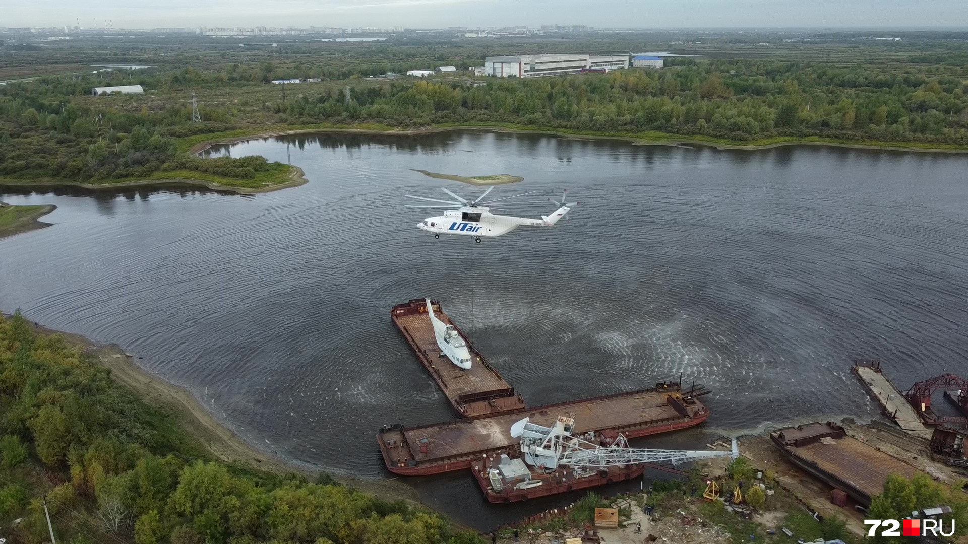 Вертолет подлетает к барже очень медленно и зависает над будущим грузом Вертолет подлетает к барже очень медленно и зависает над будущим грузом