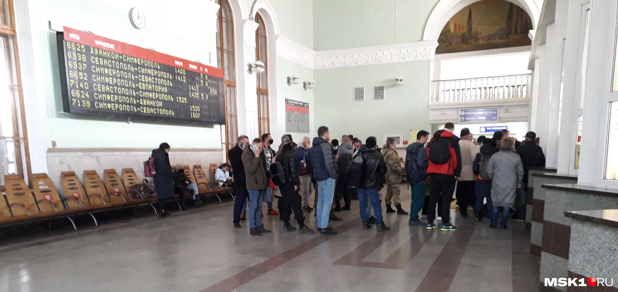 Бывшие авиапассажиры в очереди за билетами на железнодорожном вокзале Симферополя. К составам цепляют дополнительные вагоны, чтобы все поместились