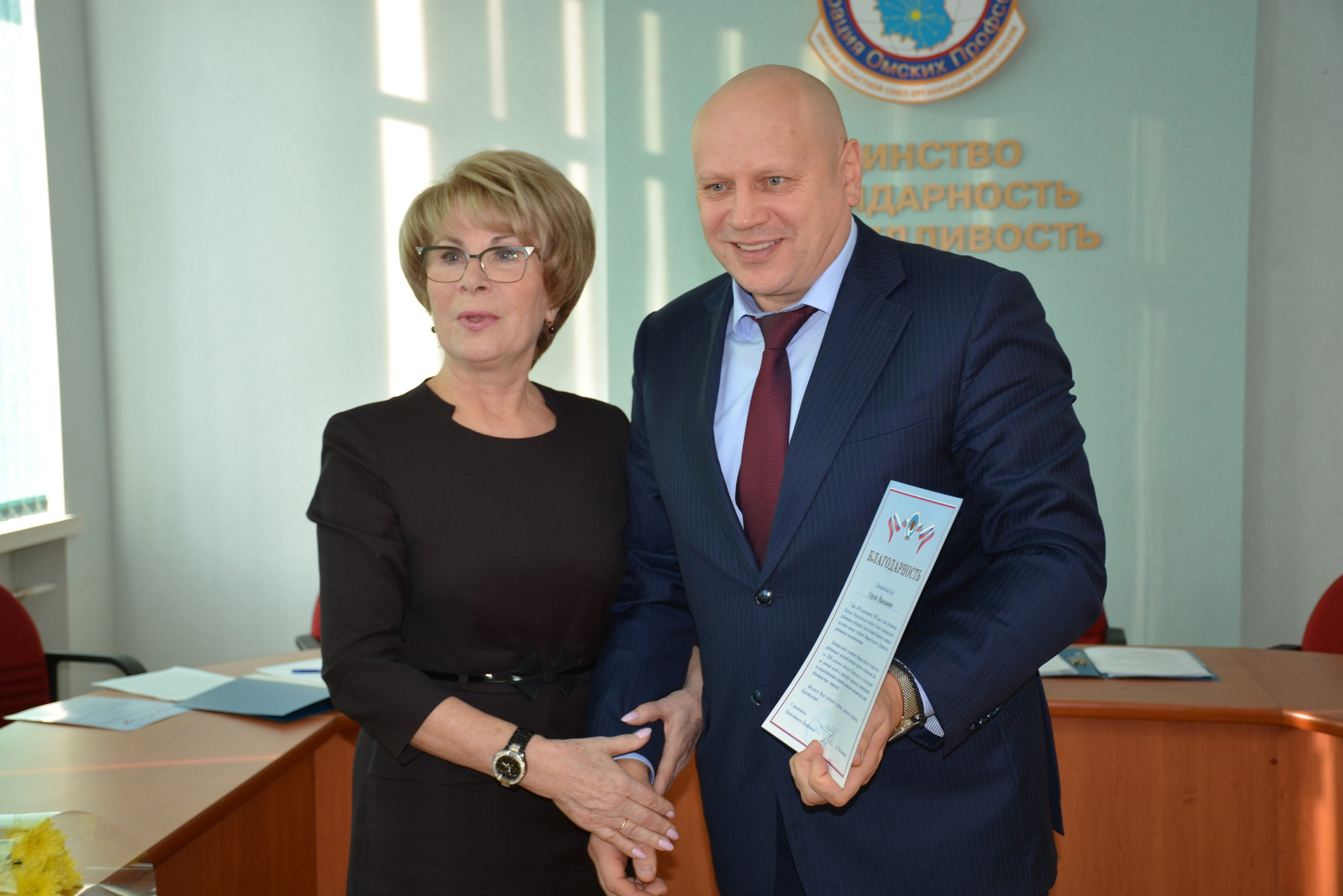 На фотографии Сергей Шелест позирует рядом с председателем конкурсной комиссии по выборам мэра Лидией Герасимовой