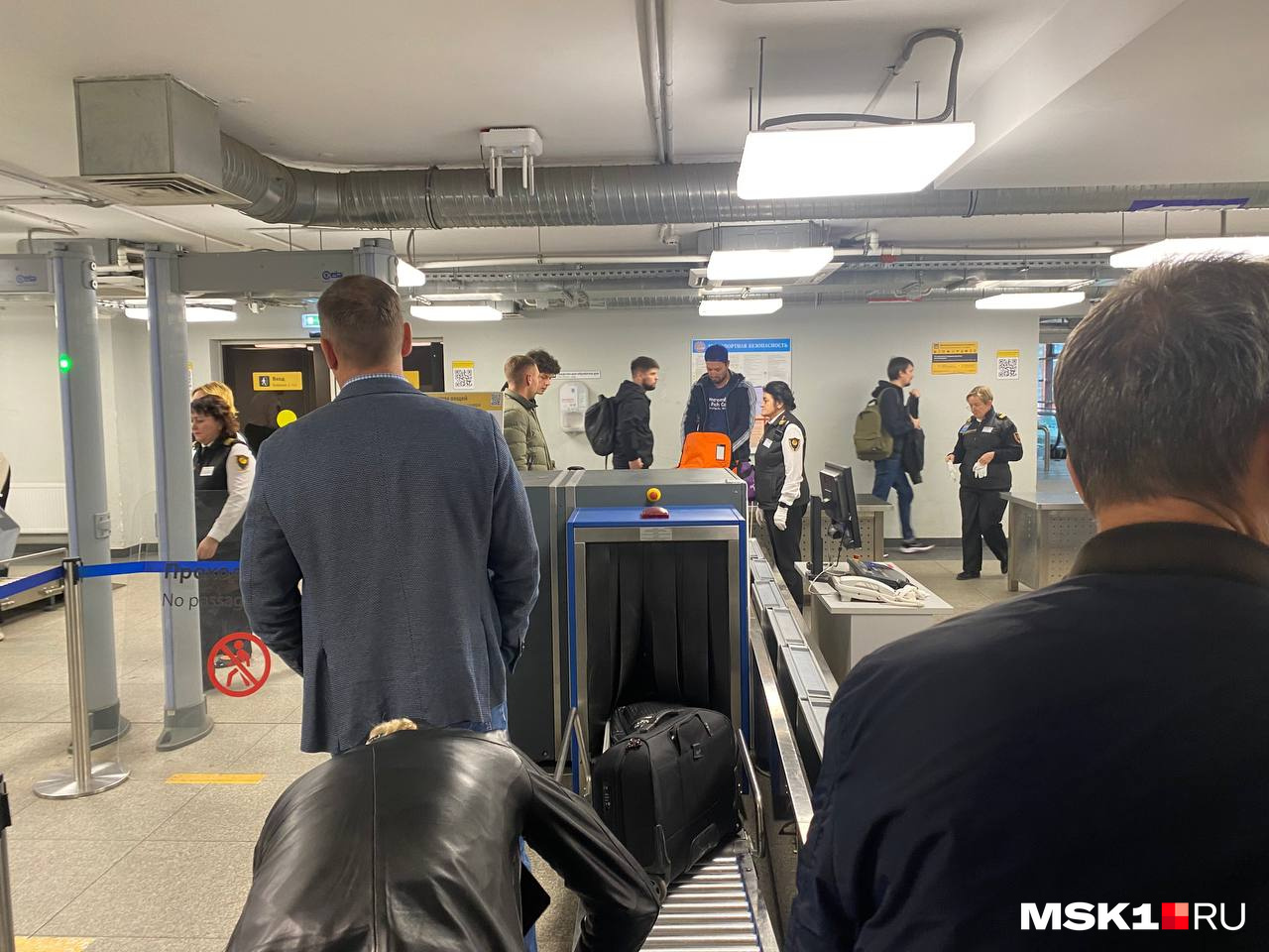 Небольшая очередь из мужчин при входе в терминал