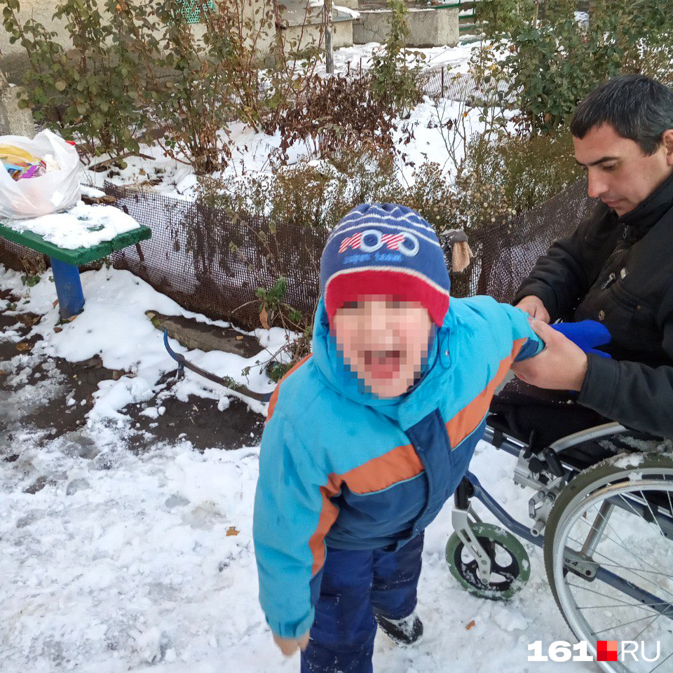 Василий надевает на сына варежку. Сын вырывается и смеется — хочет играть в снежки