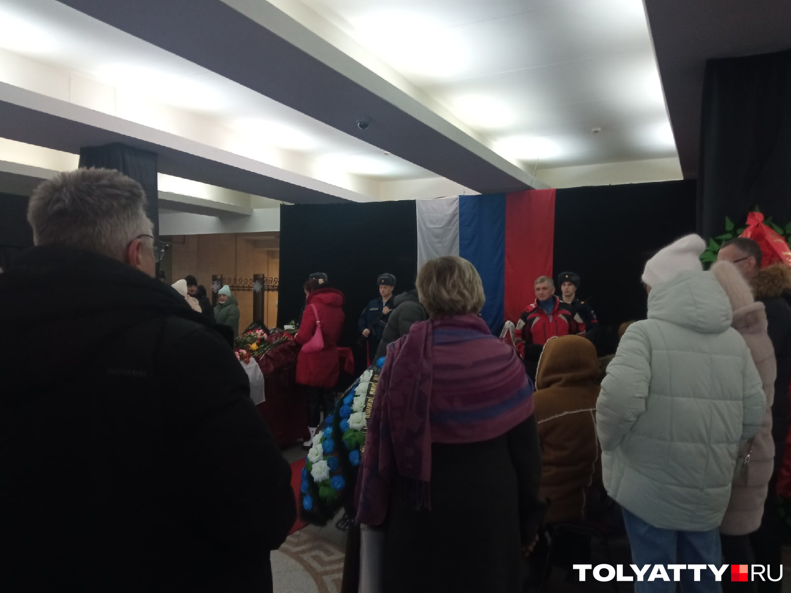 Людей в прощальном зале было много, они несли венки и цветы Людей в прощальном зале было много, они несли венки и цветы