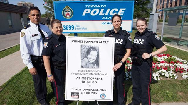 2015 год. Полиция Торонто фотографируется на фоне плаката с изображением Николь в ходе подготовки к пробегу в ее честь