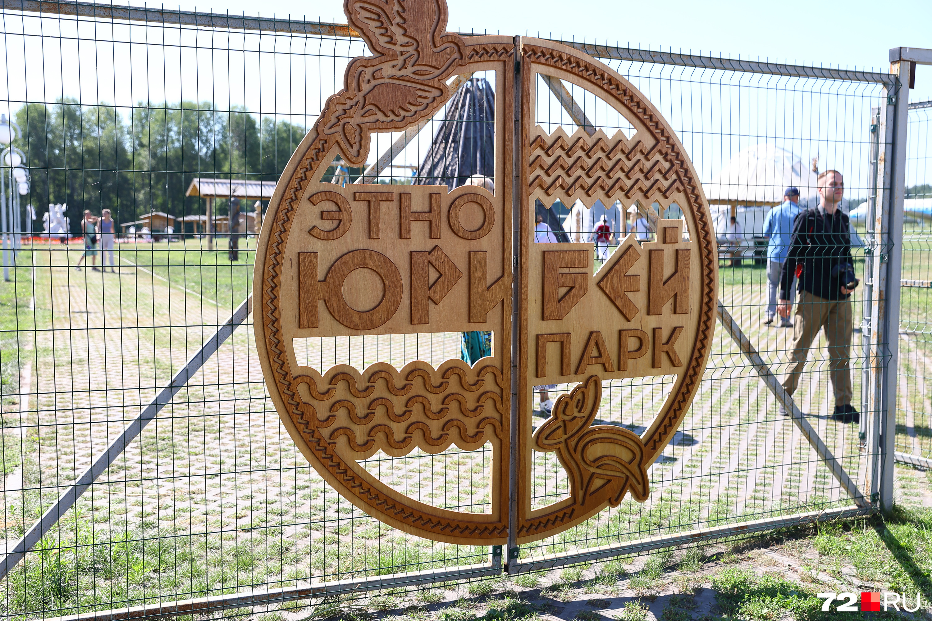 Зоопарк с выставкой техники отделяет этот забор с круглой вывеской