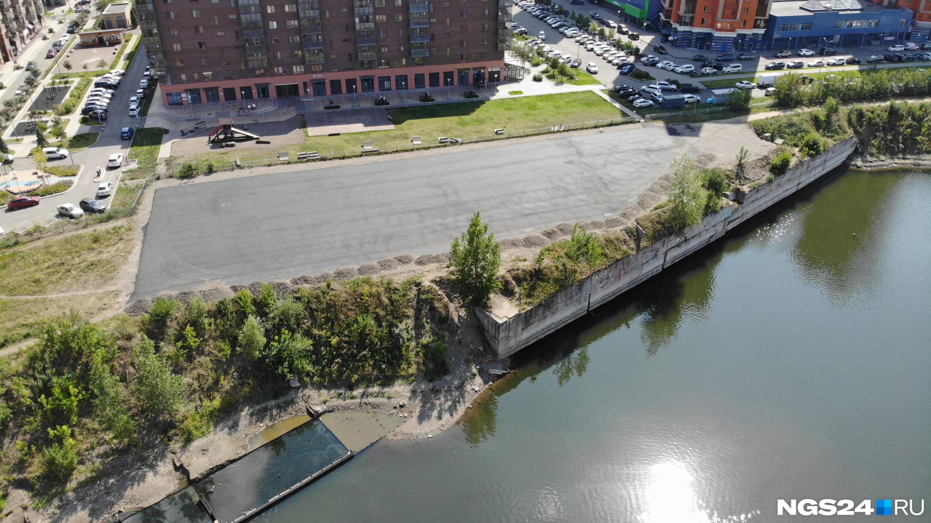 Со стороны реки видно бетонную стену и металлическую конструкцию в воде