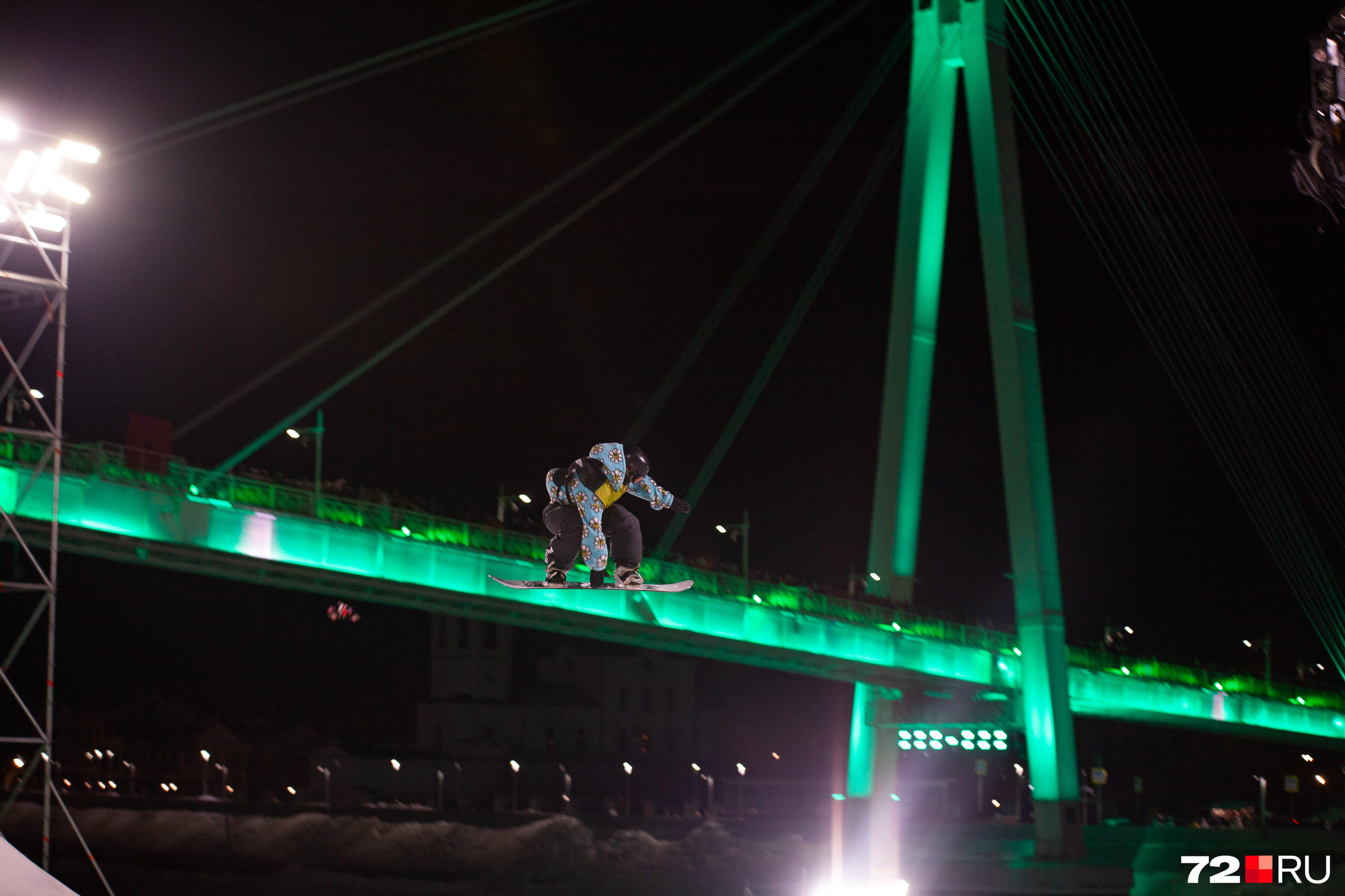 Спортсмен словно разгоняется по мосту, с которого наблюдают сотни восторженных тюменцев