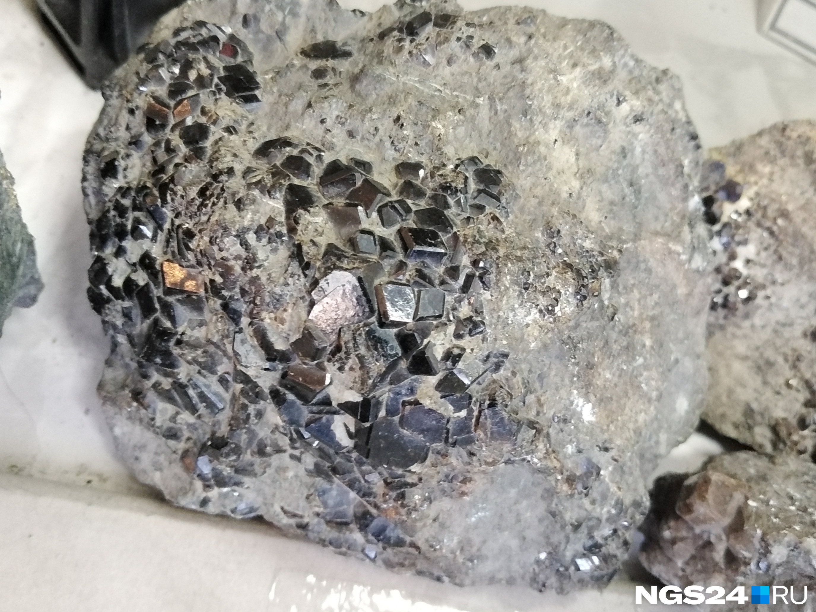 Серые булыжники покрыты кристалликами граната