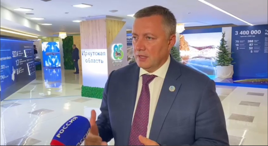 Губернатор Игорь Кобзев дает комментарий о Днях Иркутской области на фоне выставки об Иркутской области