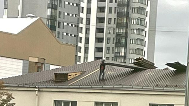 «Вот-вот свалятся на машины». В центре Екатеринбурга рабочие бросили на крыше кучу кровельных листов