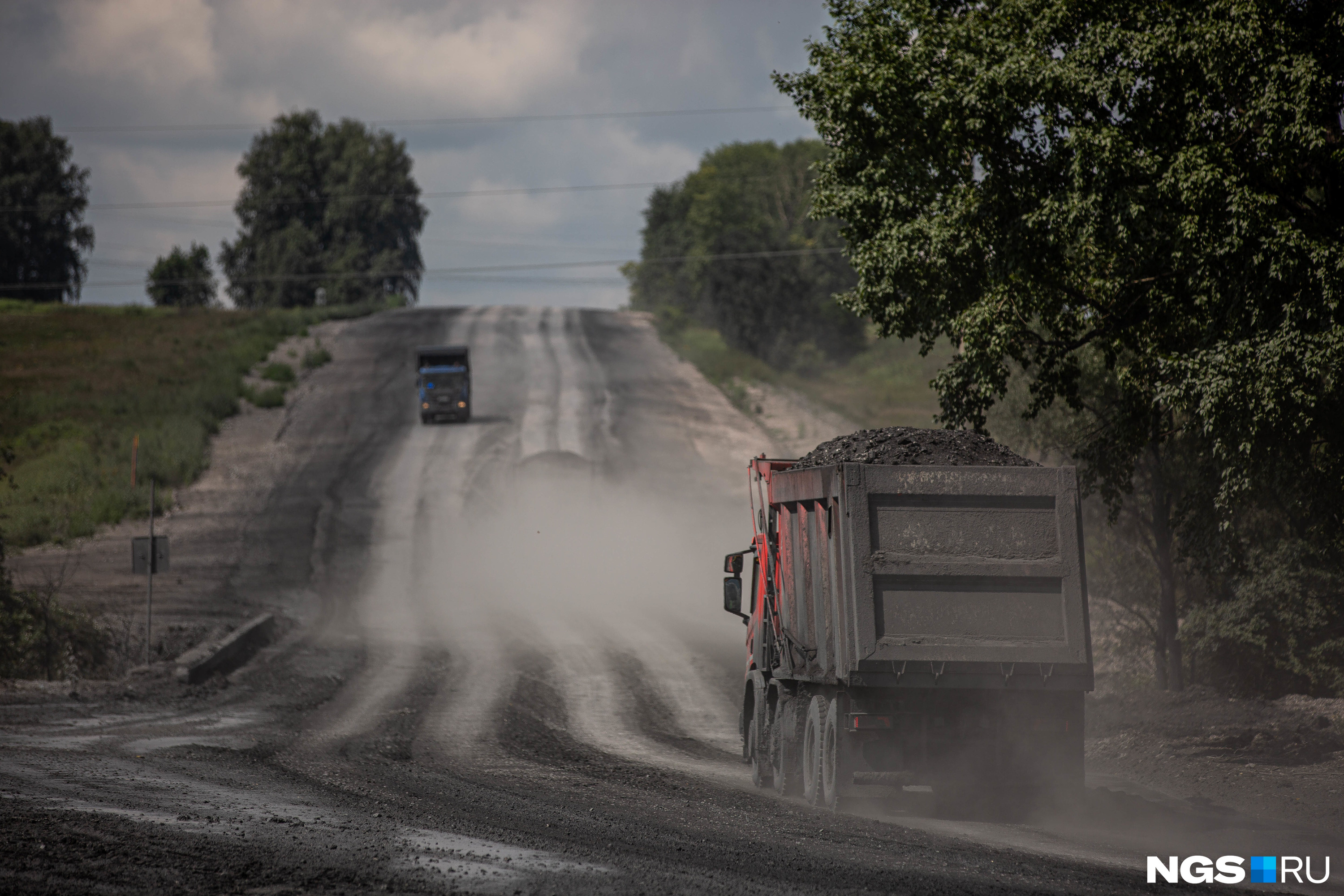Черная технологическая дорога недалеко от Ургуна, по которой грузовики вывозят уголь. Хранится он здесь тоже открытым способом