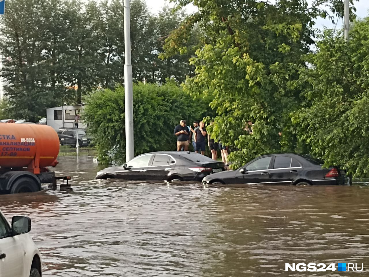 Автомобили наполовину скрыты водой, и это не самый глубокий участок