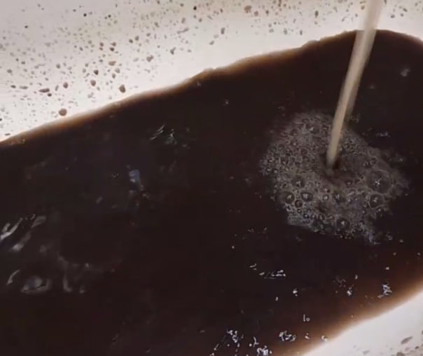 Черная вода бежит из крана в доме в центре Читы