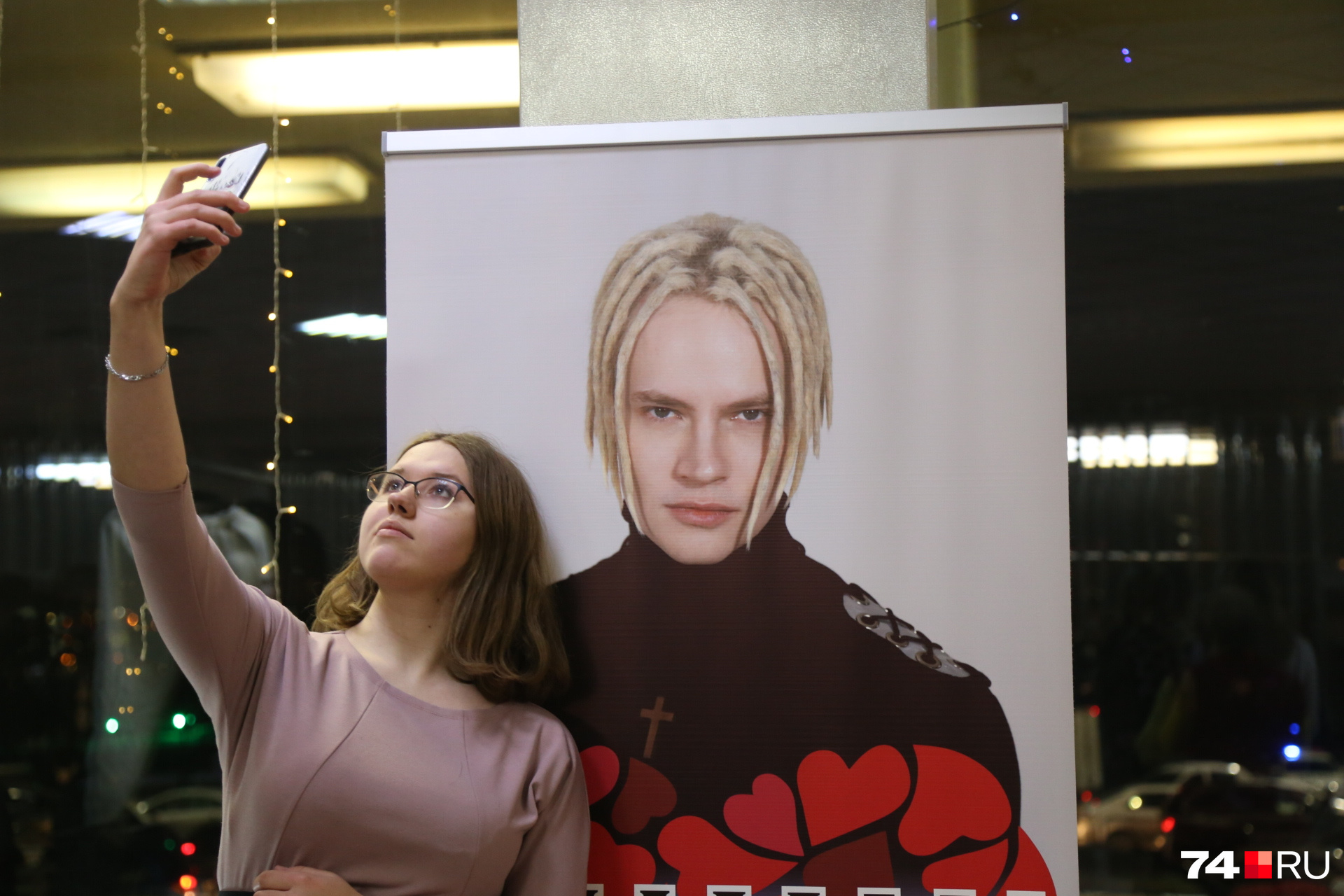 В фойе поклонники активно фотографировались с постером певца В фойе поклонники активно фотографировались с постером певца