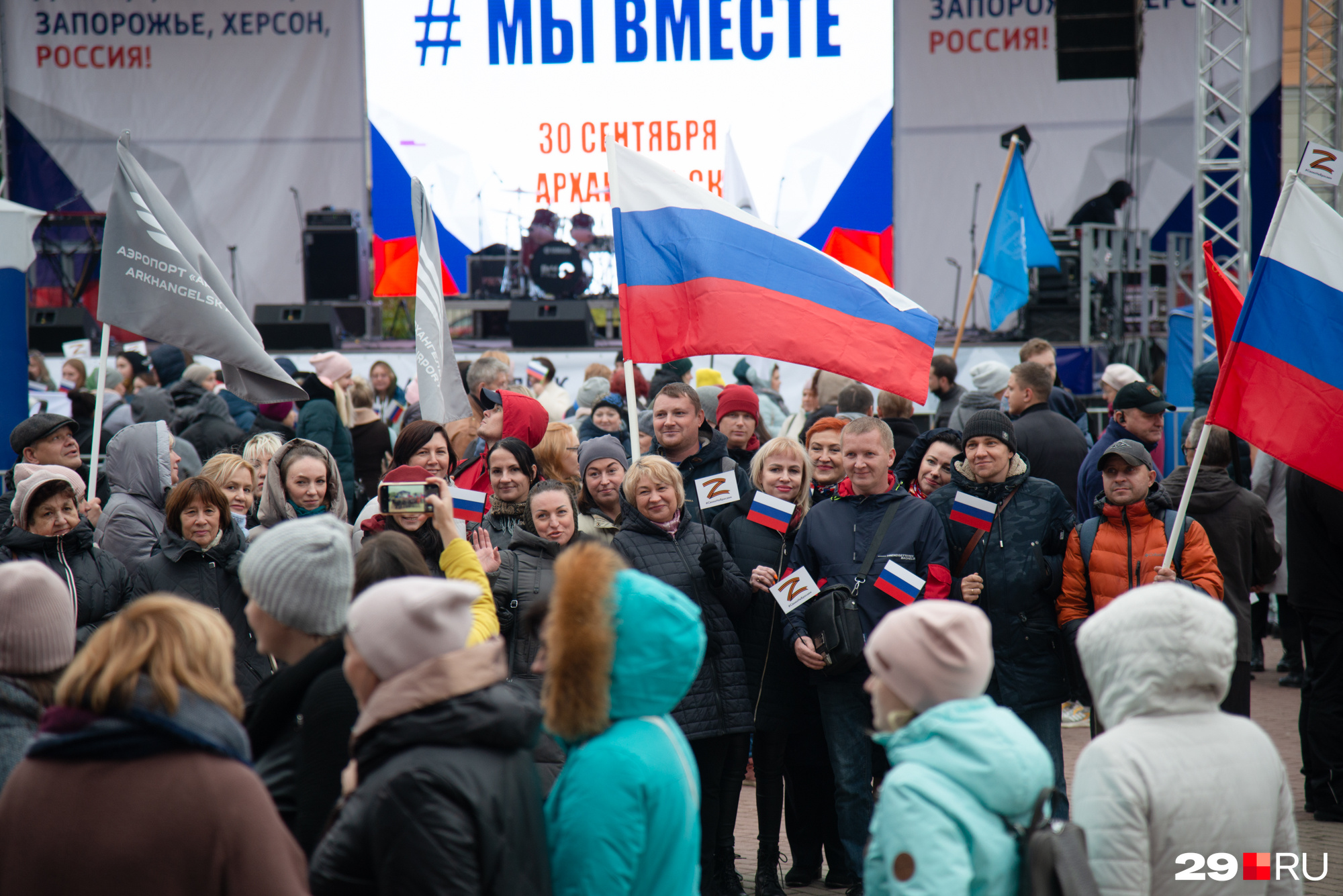 На баннерах на сцене можно прочесть: «Вместе навсегда! Выбор сделан! Донецк, Луганск, Запорожье, Херсон, Россия!» А в руках у людей — флаги