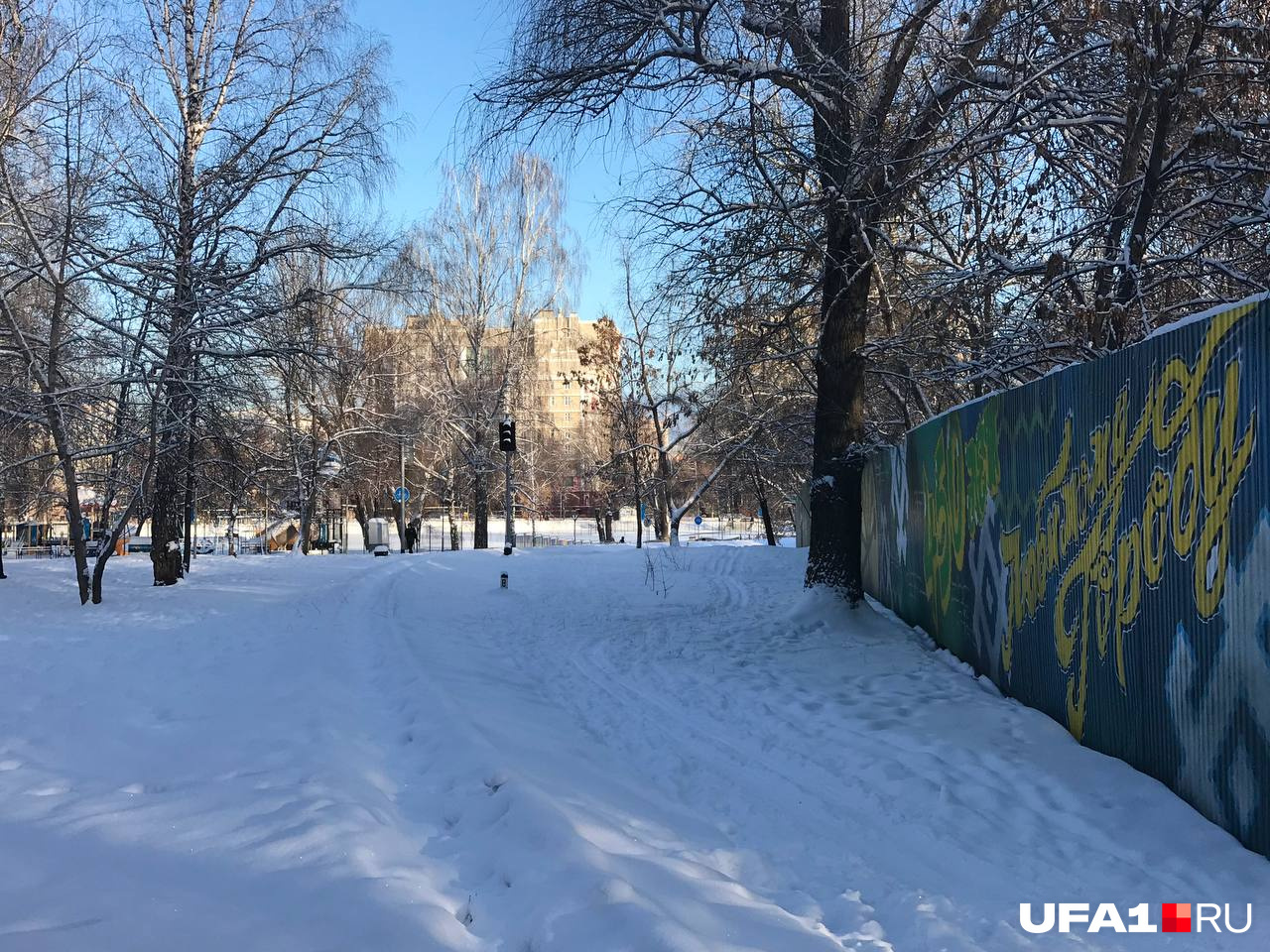 Покрытая снегом железная дорога в парке