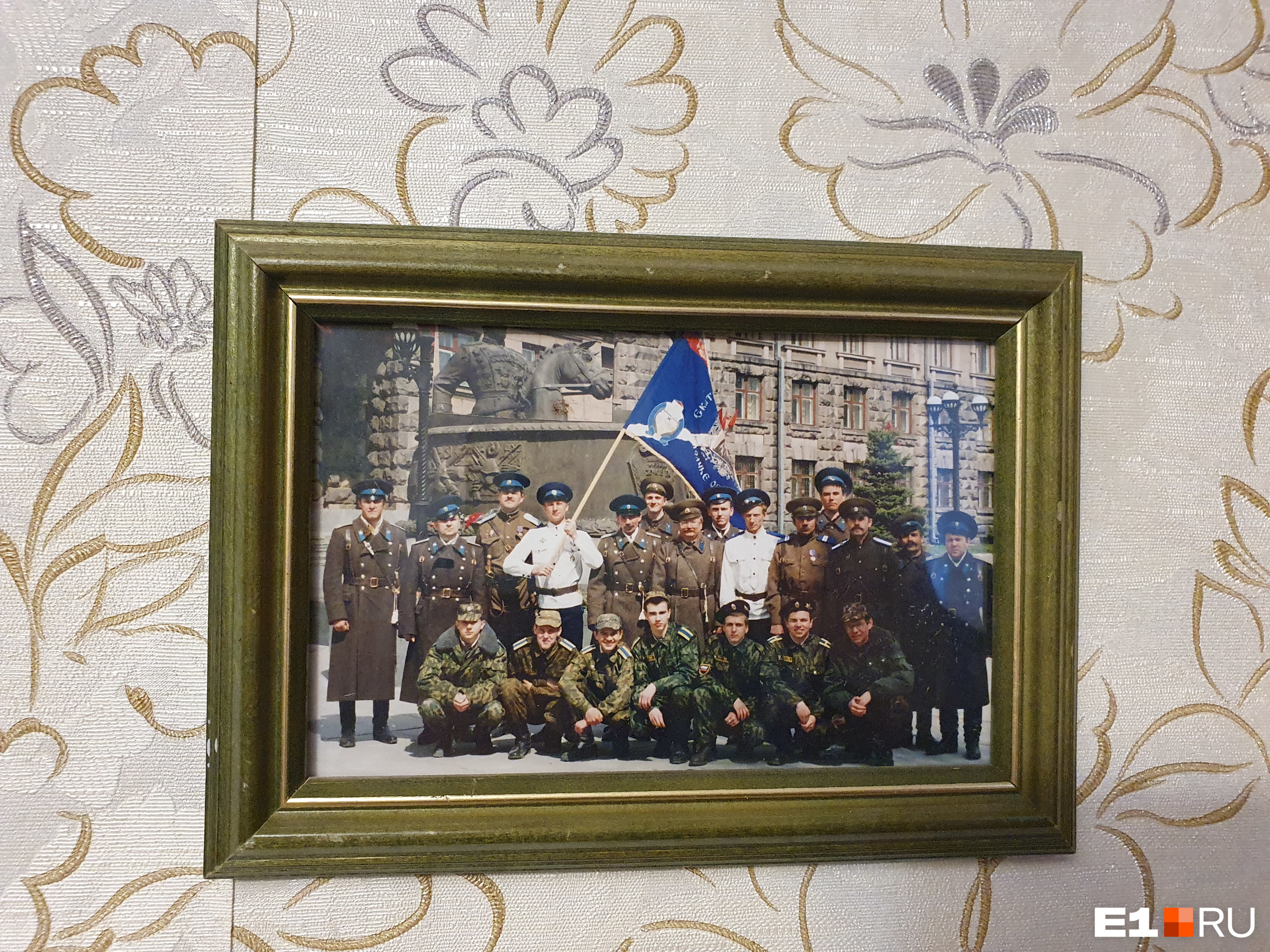 На стене в квартире ветерана — фото с сослуживцами
