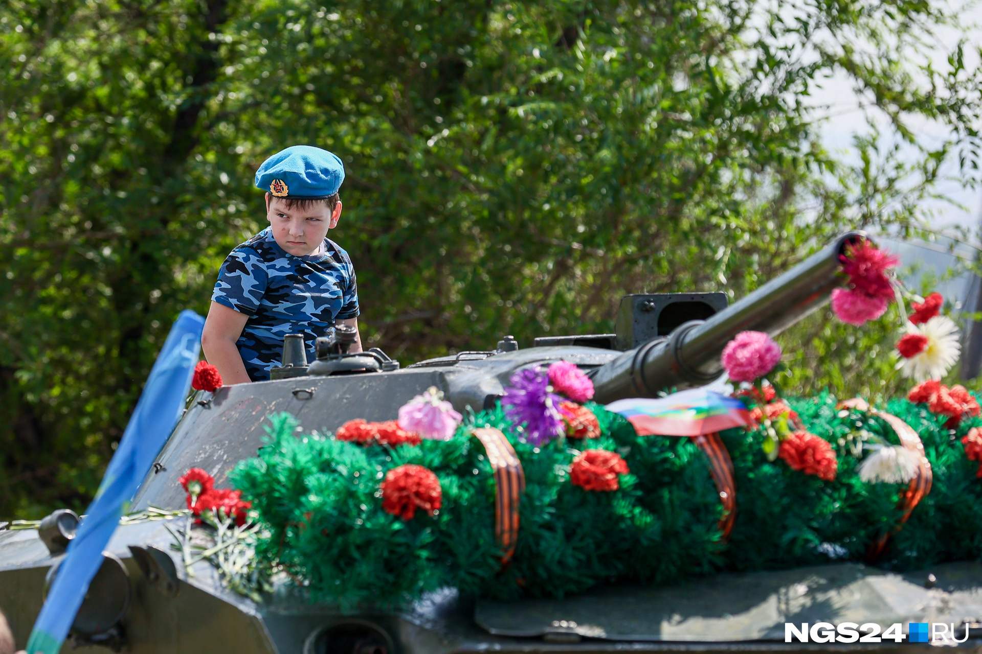 Сын десантника на боевой машине десанта, украшенной цветами в честь Дня ВДВ