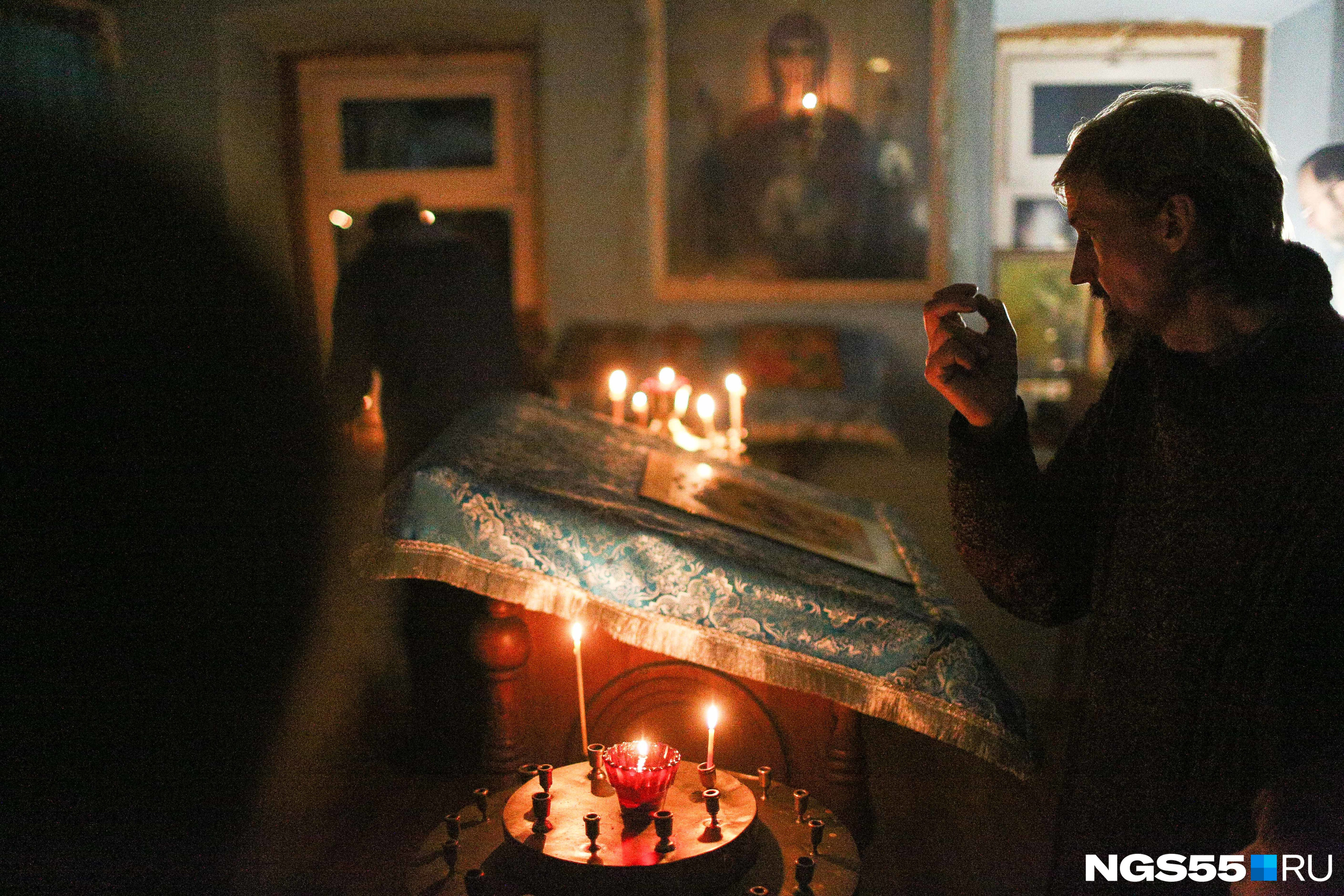 В полумраке горели свечи и освещали иконы. Посетители храма молились о своих близких