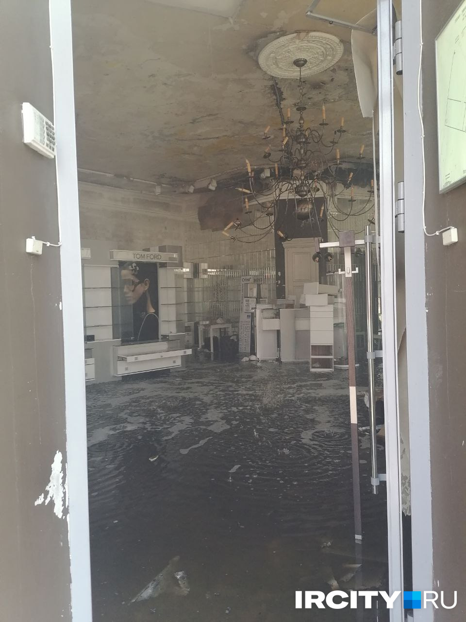 Магазин оптики на первом этаже, пострадавший от пожара. Его вход располагался с торца здания