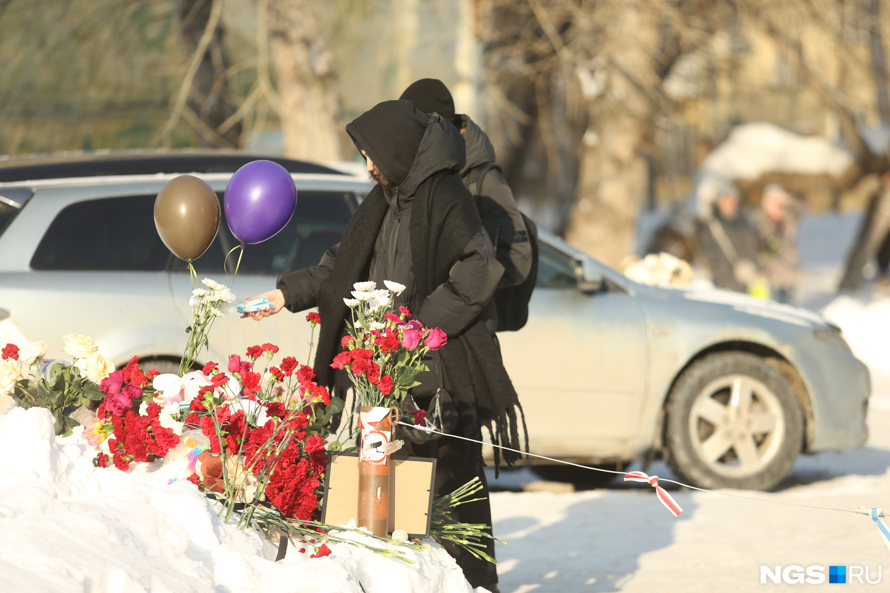 Сочувствующие люди продолжают приносить цветы и детские игрушки к небольшому мемориалу на снегу
