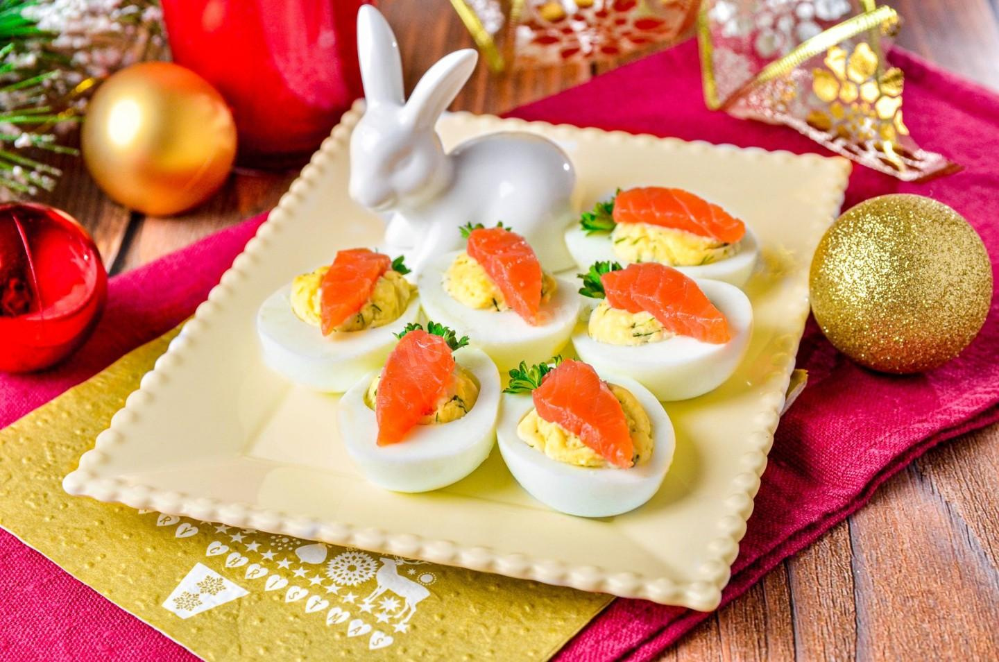 Очень простые и легкие закуски можно сделать из яиц. Например, для таких «морковных горок» надо сварить яйца, желток смешать с плавленым сыром и начинить им белок. Сверху положите кусочек красной рыбы, вырезанный в виде моркови, и зелень для украшения