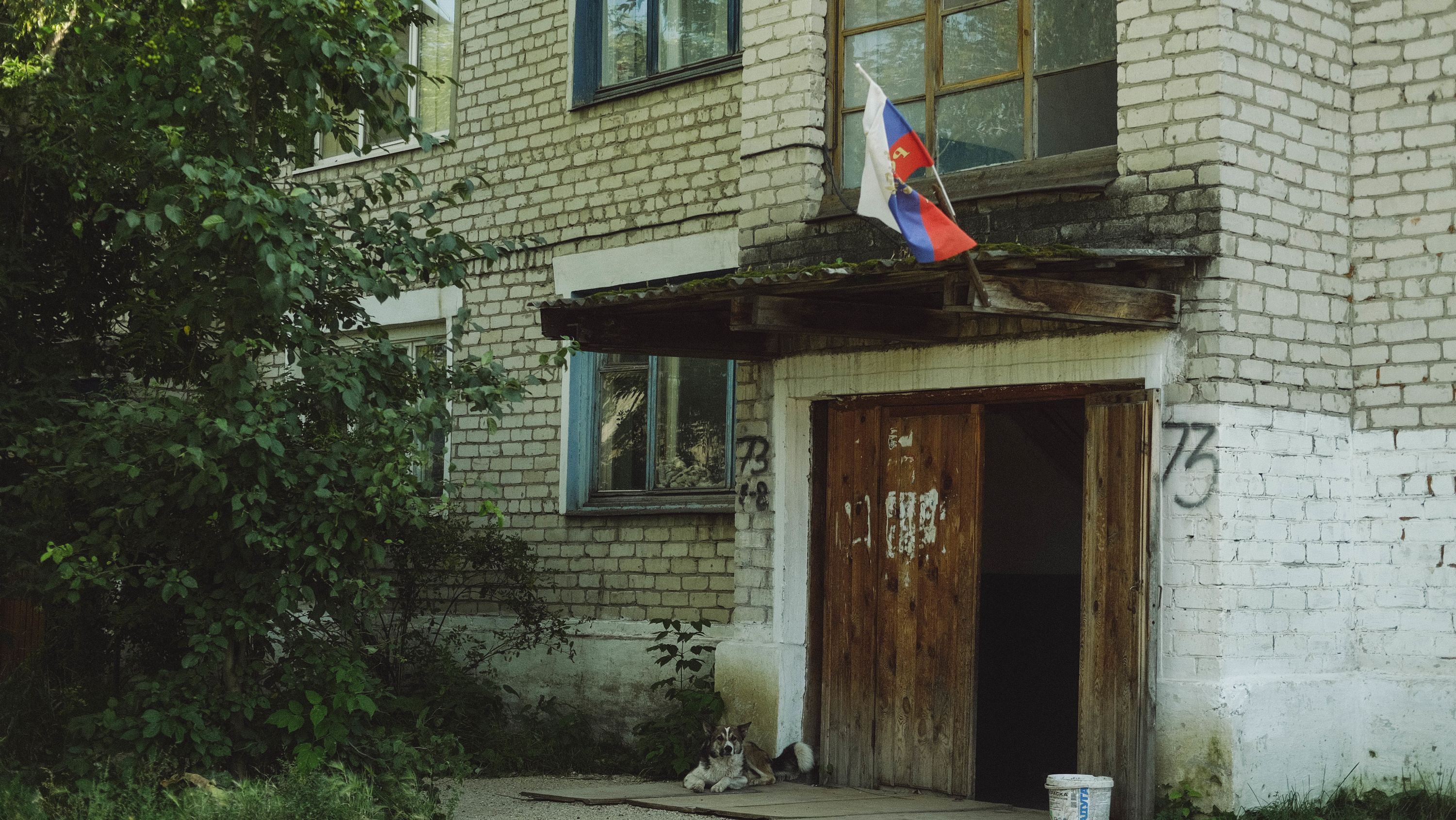 На стареньких многоэтажках, полуразвалившихся заборах и ларьках пестрят флаги России