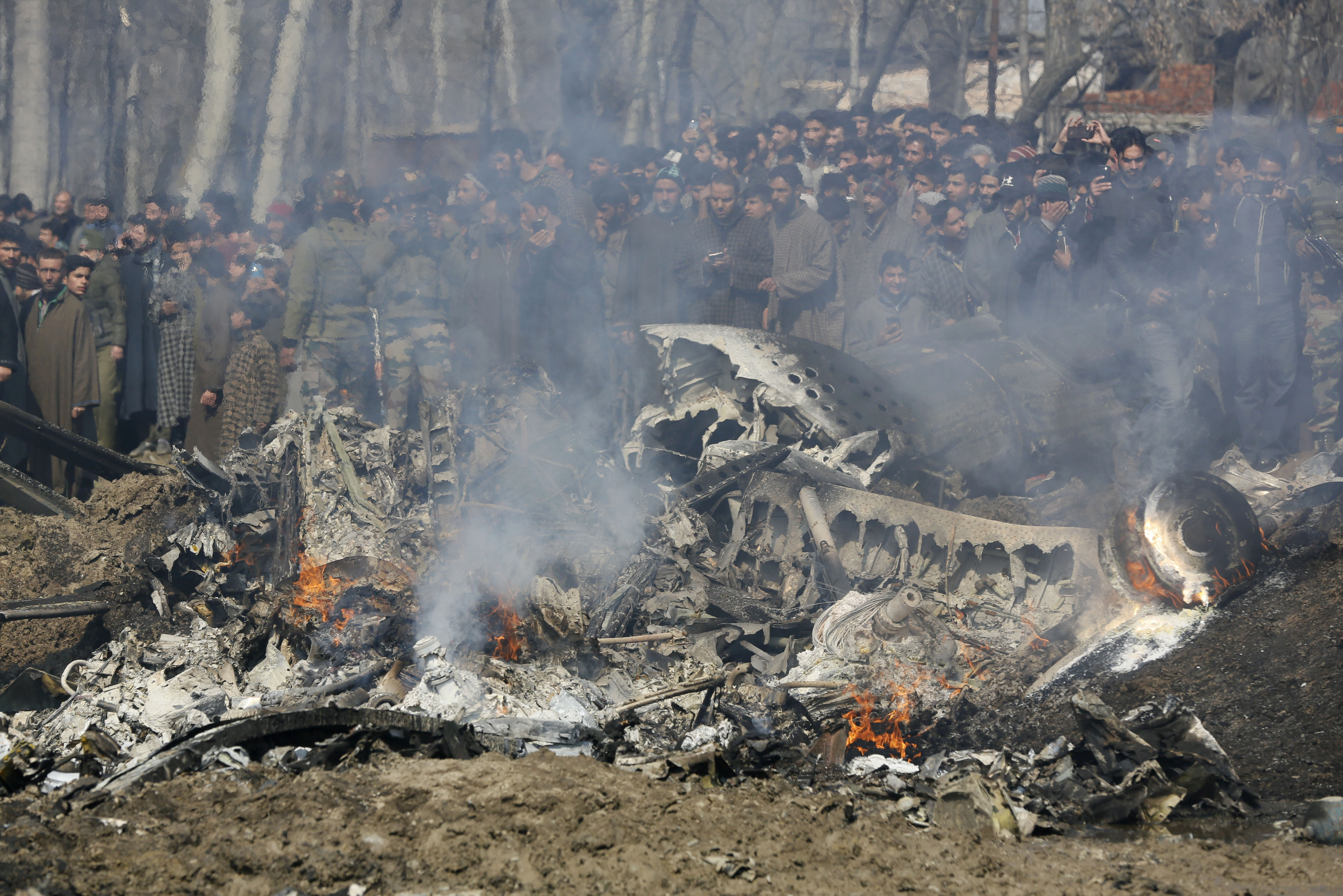 Индия. Местные жители на месте катастрофы самолета ВВС Индии, потерпевшего крушение в индийском штате Джамму и Кашмир. Два пилота не успели катапультироваться и погибли.