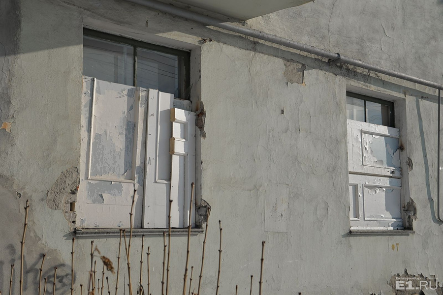 Заколоченные фрагментами дверей окна на Белинского, 250.