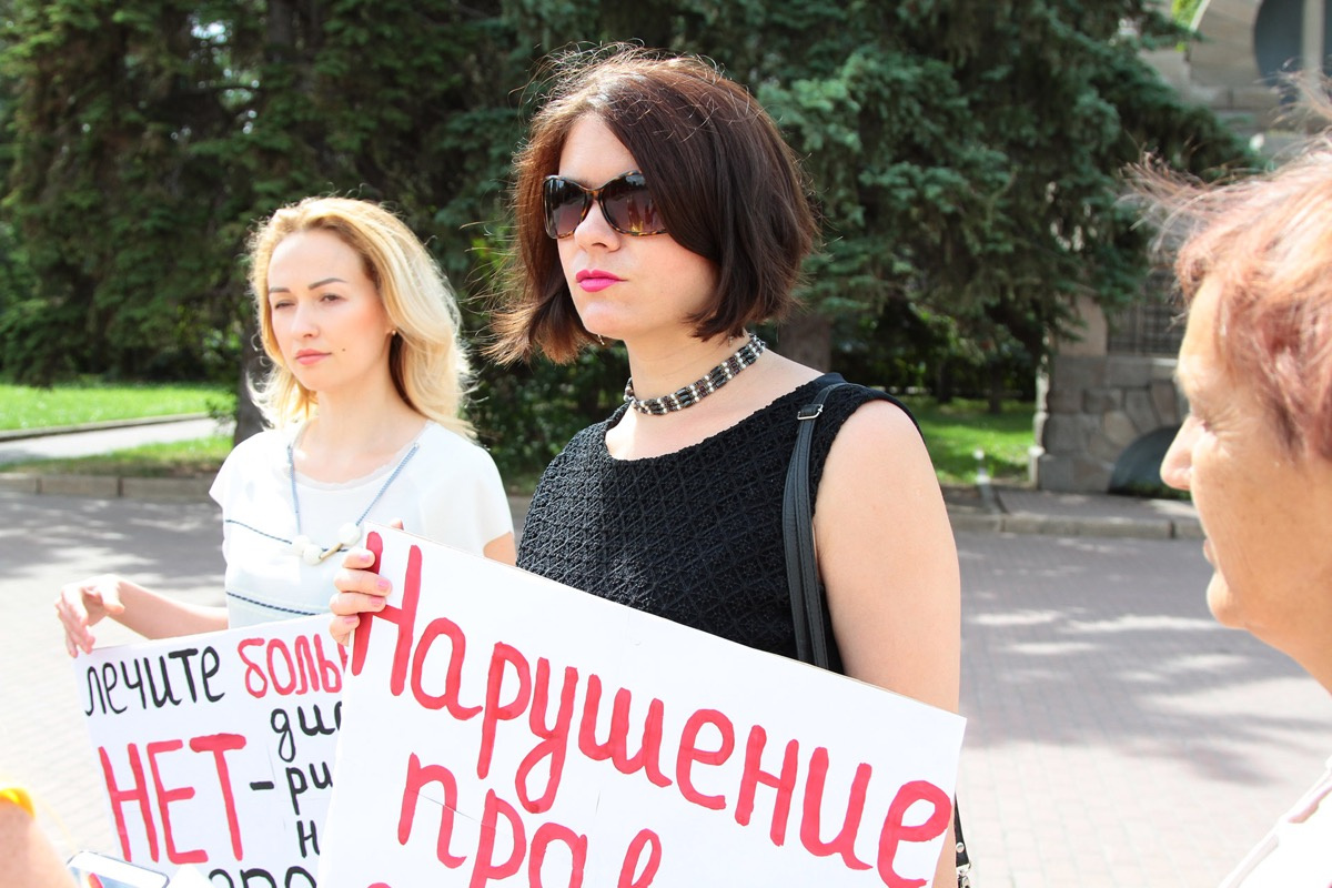 В руках женщины держали плакаты с призывами не дискриминировать детей без прививок В руках женщины держали плакаты с призывами не дискриминировать детей без прививок