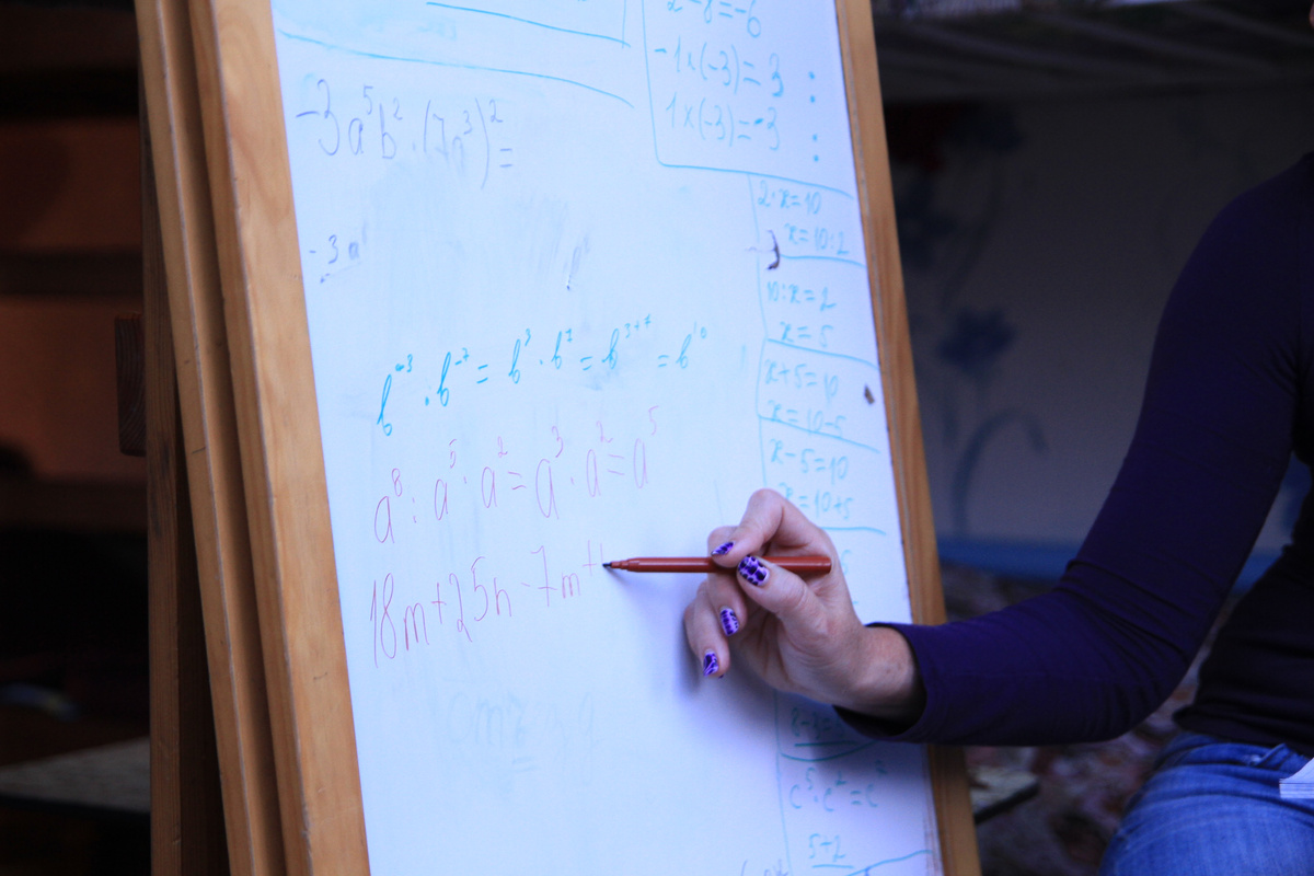 Ирина на доске показывает, как решать простые примеры и уравнения