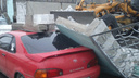 Магнитогорский тракторист, перепутав педали, уронил бетонный забор на две машины