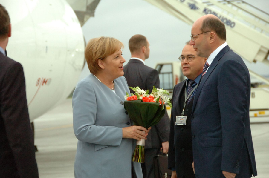 Александр Мишарин во время ШОС встречает Ангелу Меркель.
