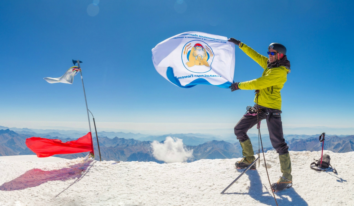 Александр с флагом тюменского центра зимнего плавания, который остался в горах насовсем. Таковы традиции альпинистов