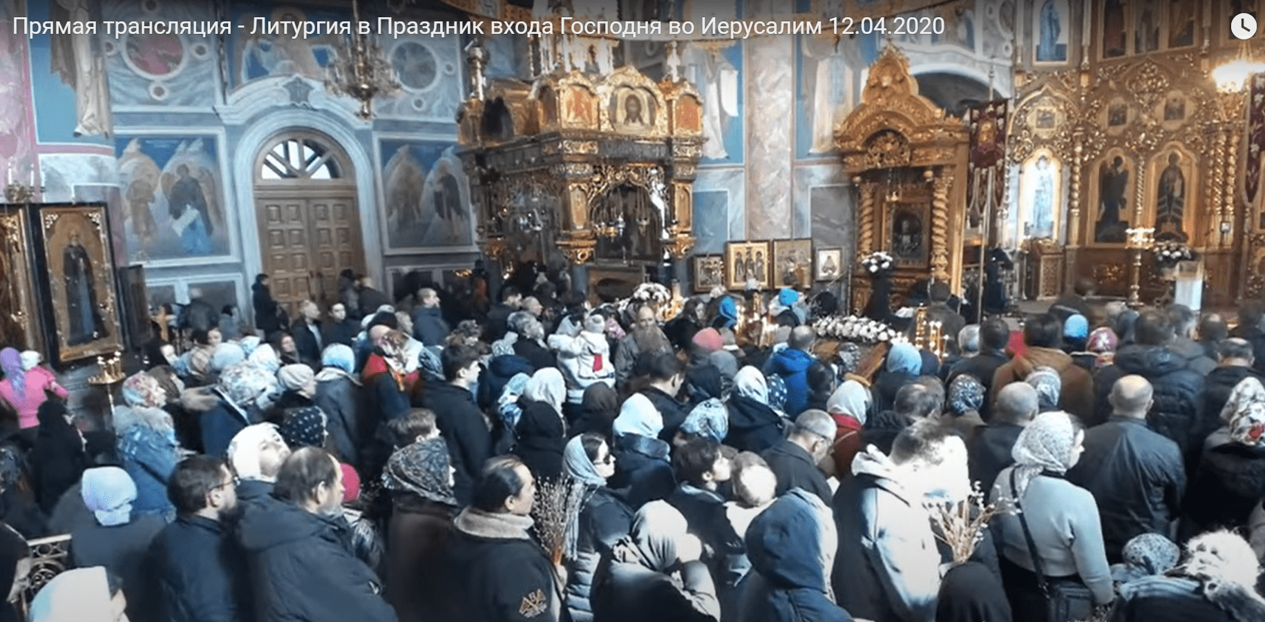 Скриншот прямой трансляции литургии в Дивеево. Запись длится 2,5 часа, всё это время в кадре — полно людей.