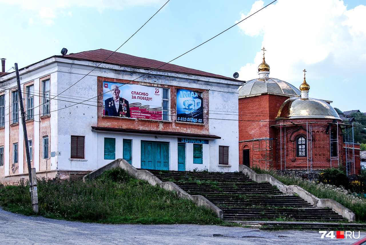 Здание кинотеатра с рекламой IMAX 3D и церковь на фоне — это Усть-Катав