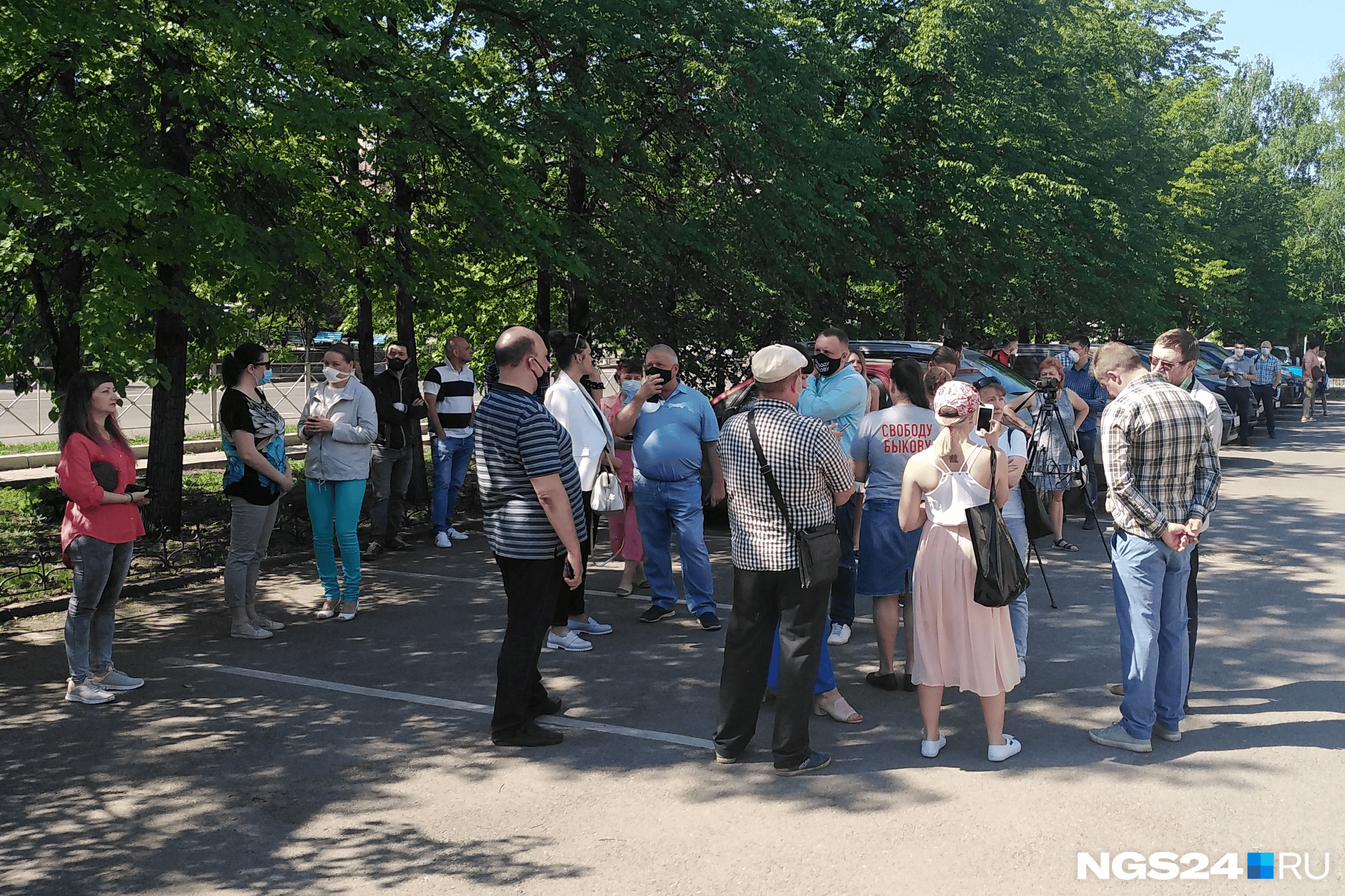 Несколько десятков человек стояли в тени перед зданием суда Несколько десятков человек стояли в тени перед зданием суда