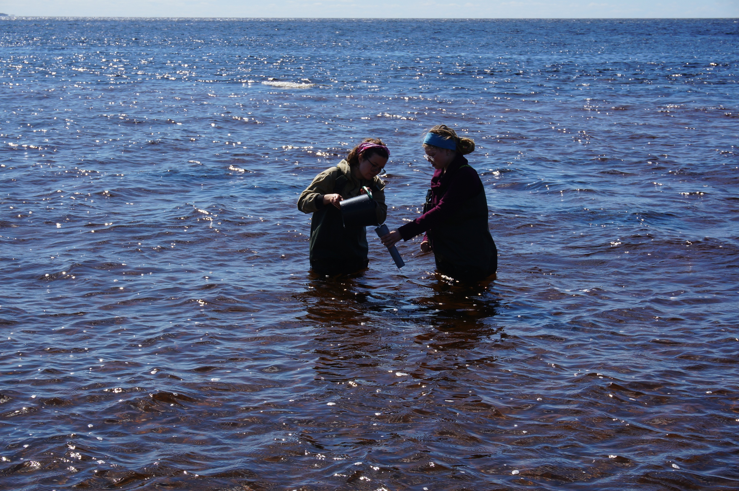 Девушки берут пробы морской воды, чтобы потом посмотреть, содержатся ли в них микрочастицы пластика — это цель их поездки