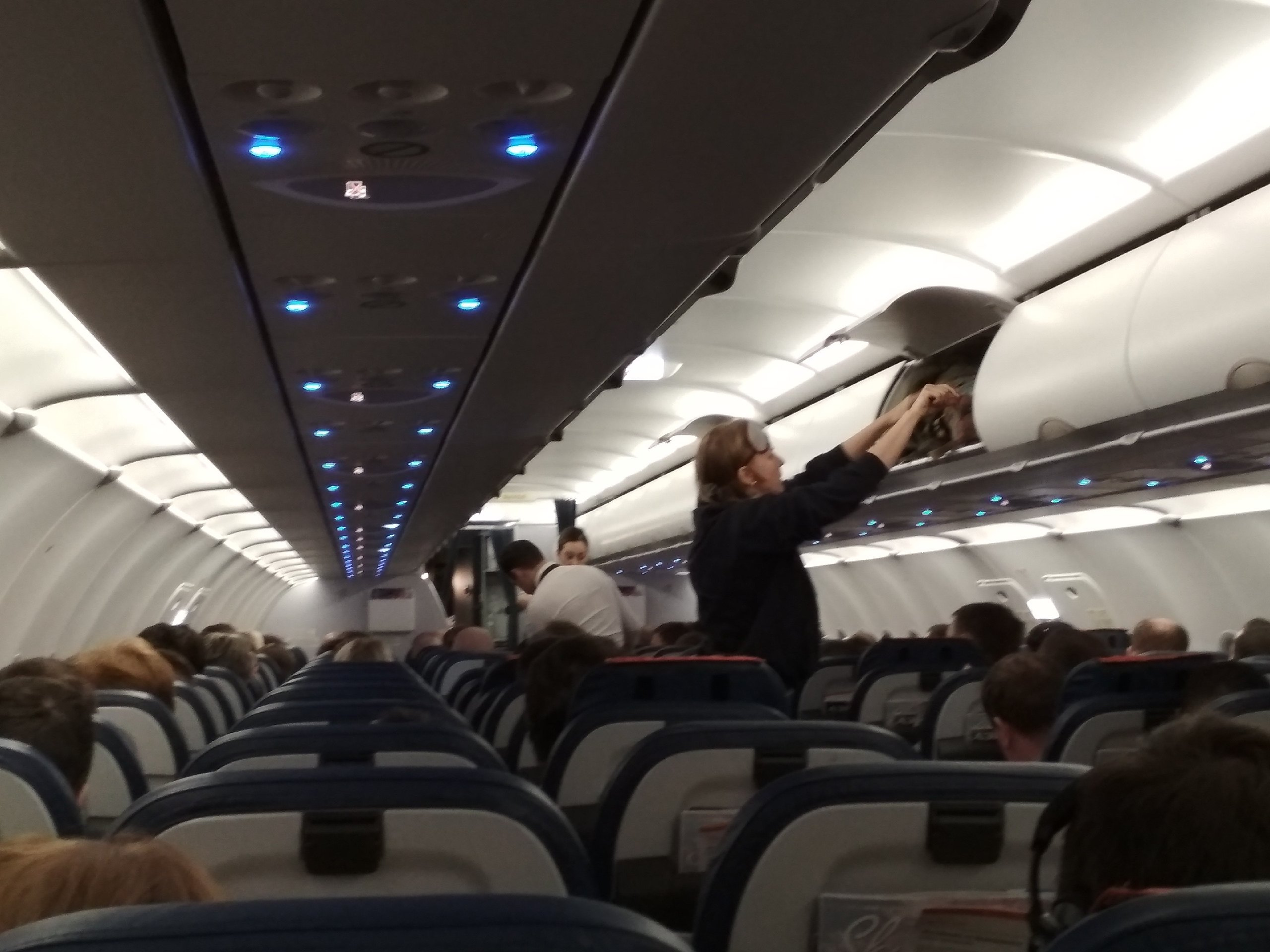 Пассажиры сидят в самолёте и пьют сок