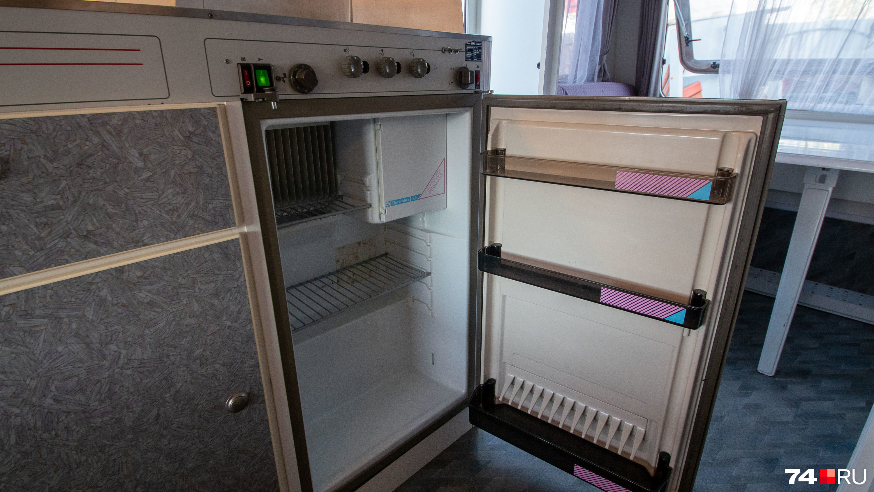 Кухонная зона компактная, но вместительная: есть небольшой холодильник, плита и шкафчики для посуды
