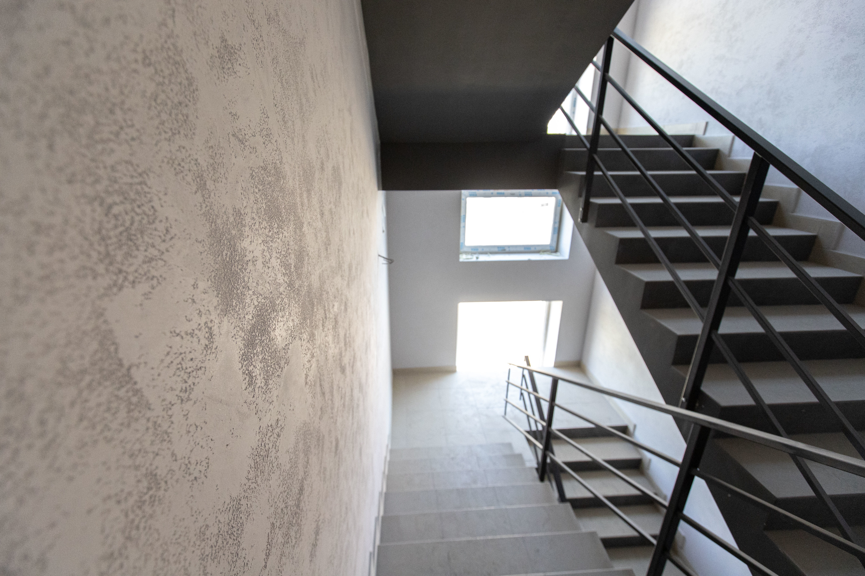 Эвакуационная лестница с финишной отделкой — стены облицованы декоративной штукатуркой 