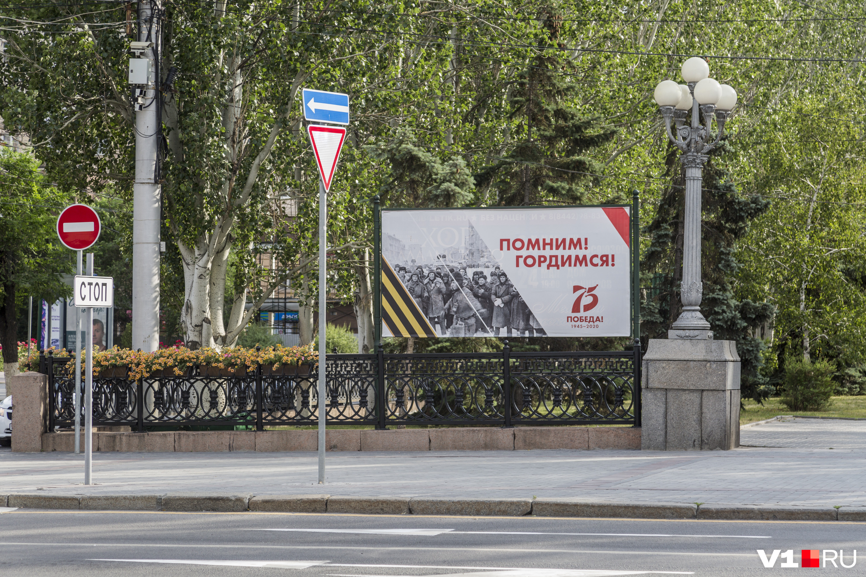 Комсомольцы Сталинграда смотрят прямо на плакат с надписью "Помним, гордимся".