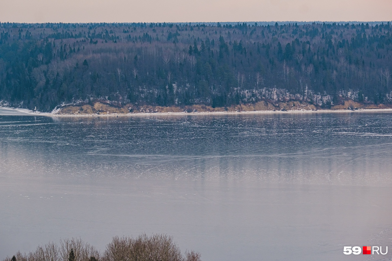 Зеркальный лед отражает лес на берегу