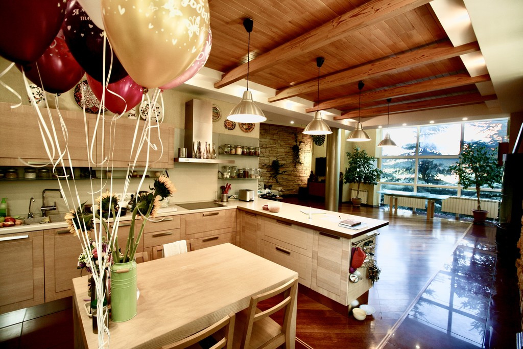 Потолки кухни декорированы деревянными балками — по моде