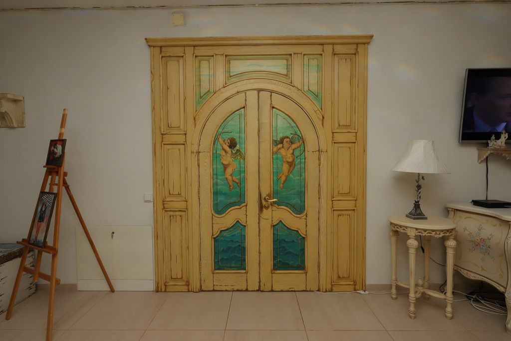 Одна из необычных деталей интерьера — дверь с изображением купидонов