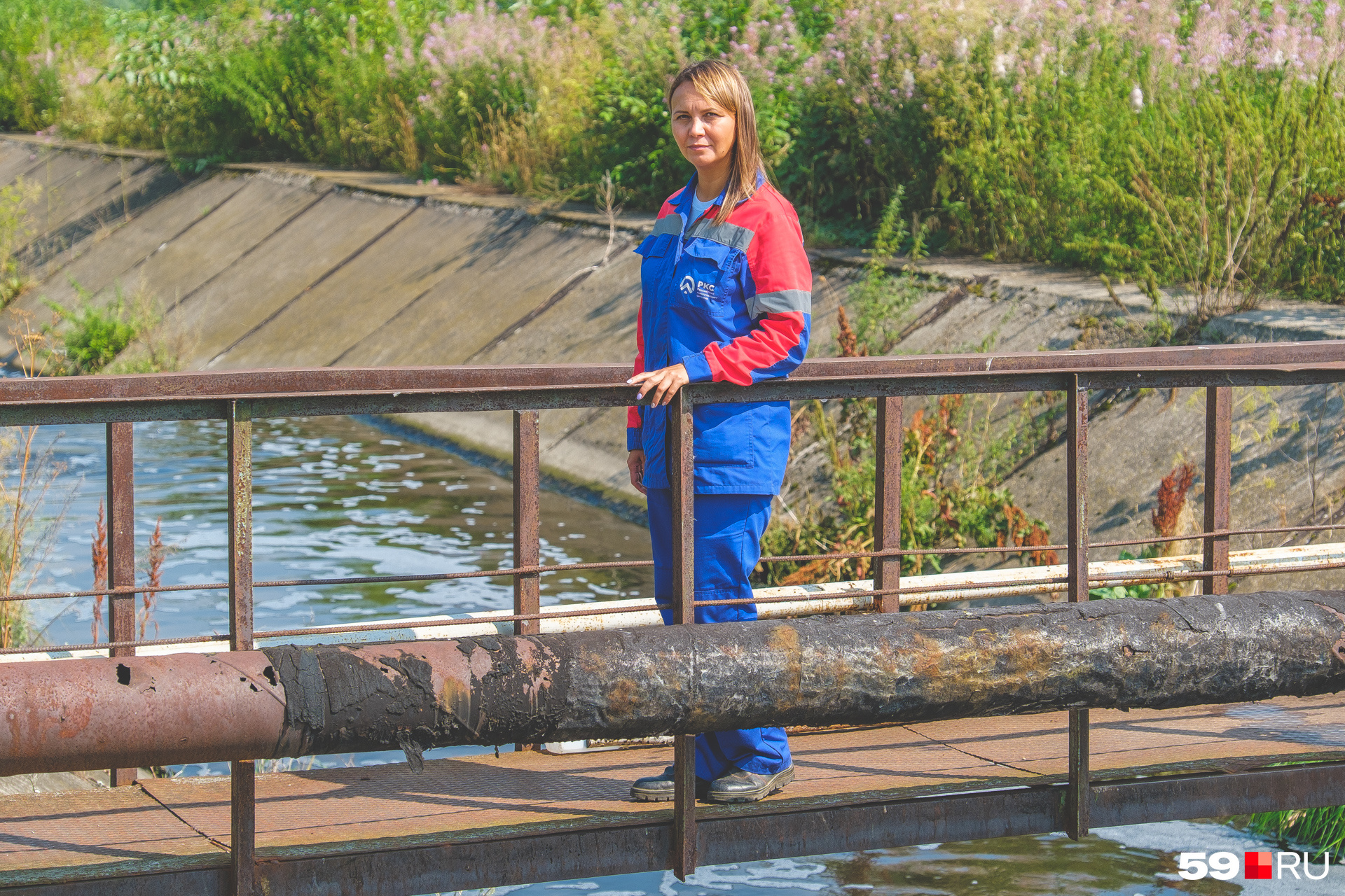 Анна Дудакова стоит на мостике над каналом с очищенной водой. Тут пахнет свежестью и рекой