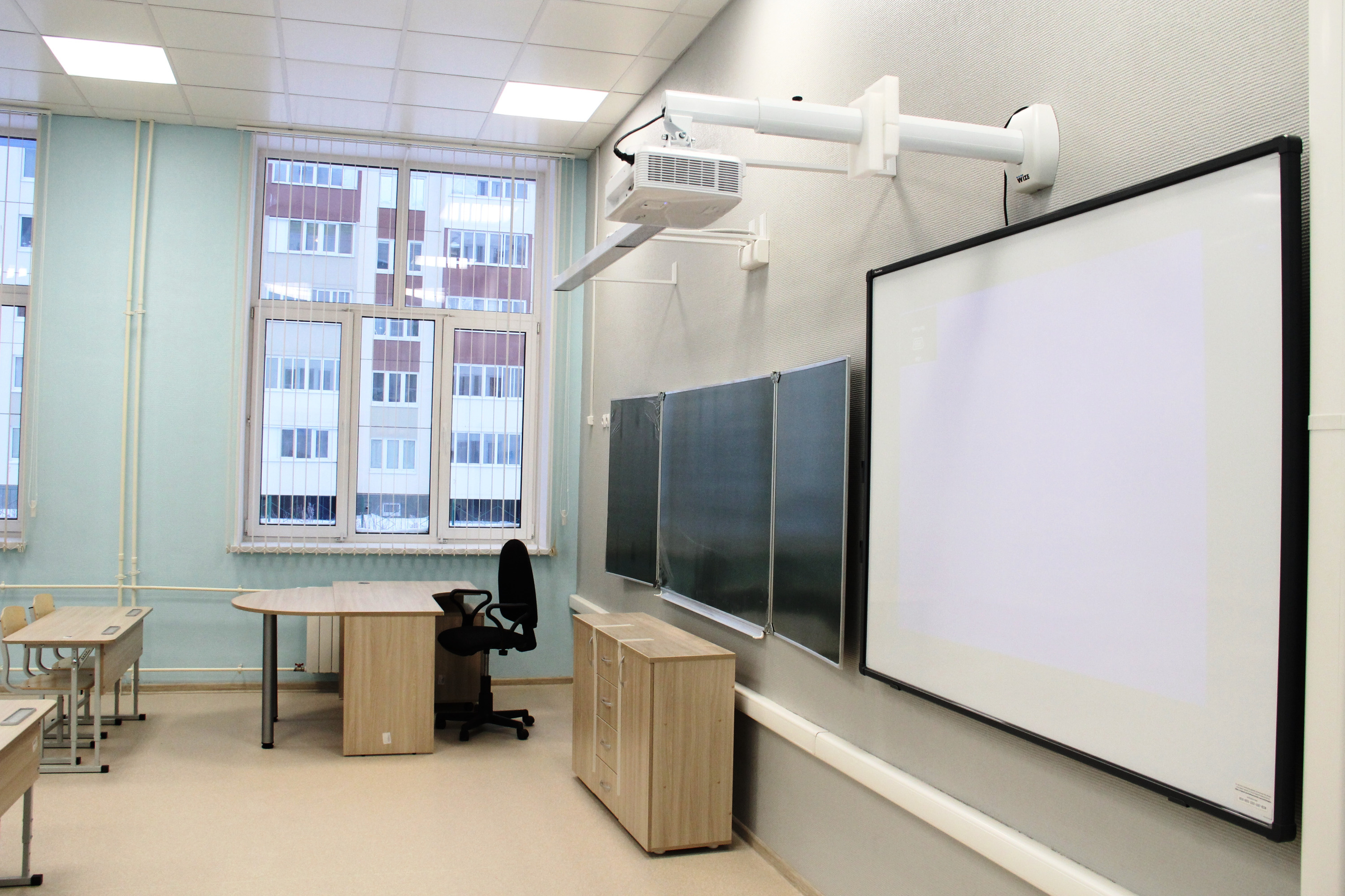 Типичный школьный кабинет — доска, видеоэкран и проектор