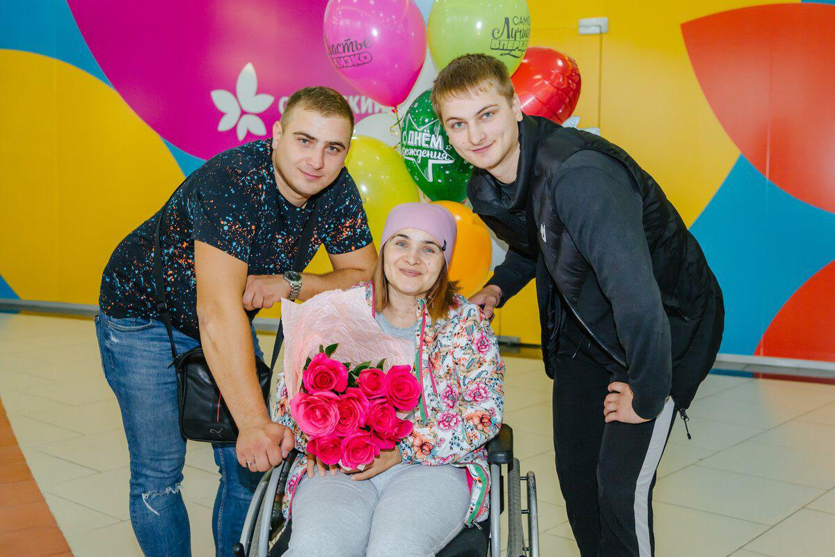 Сыновья по очереди помогают маме и носят её на руках Сыновья по очереди помогают маме и носят её на руках